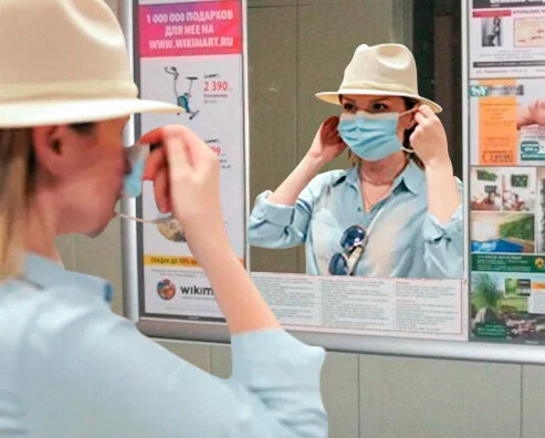 Фото девушки в маске и рекламного стенда с зеркалом в лифте Казани